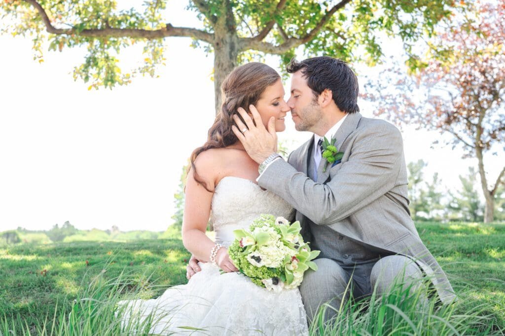 bride and groom sitting under tree