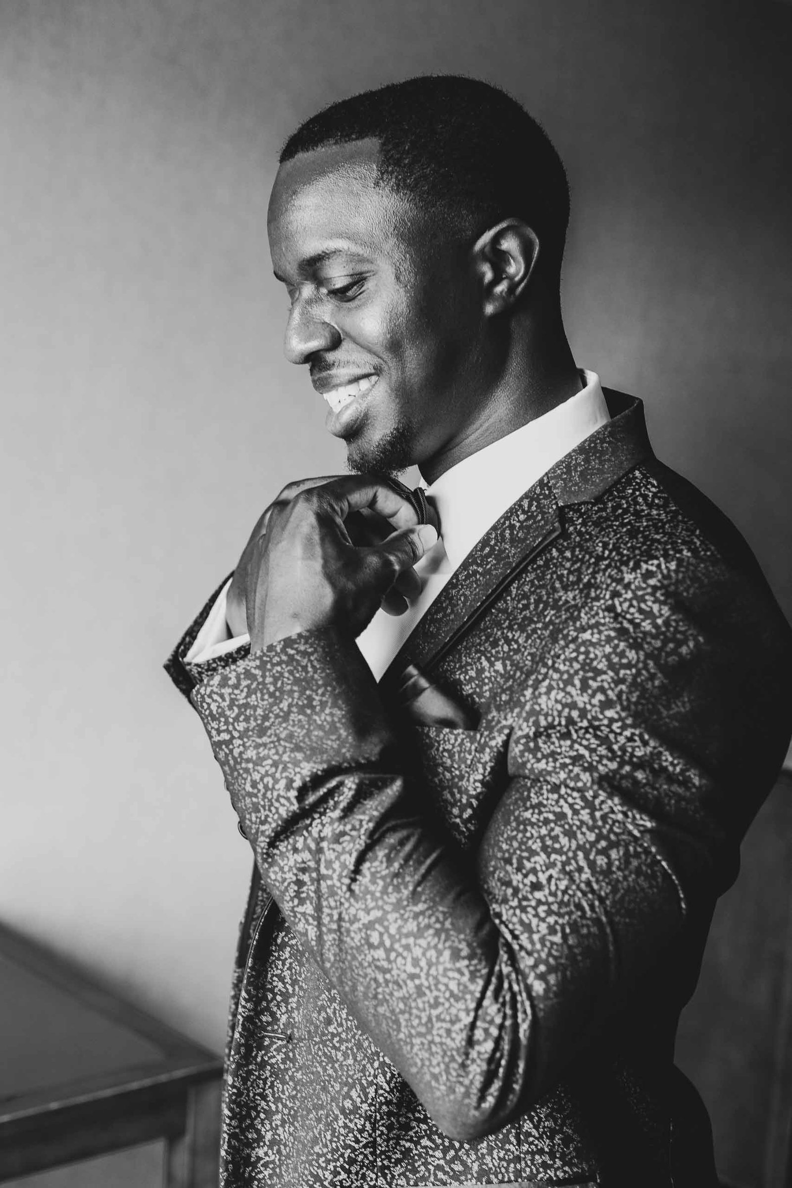 black groom adjusts bowtie