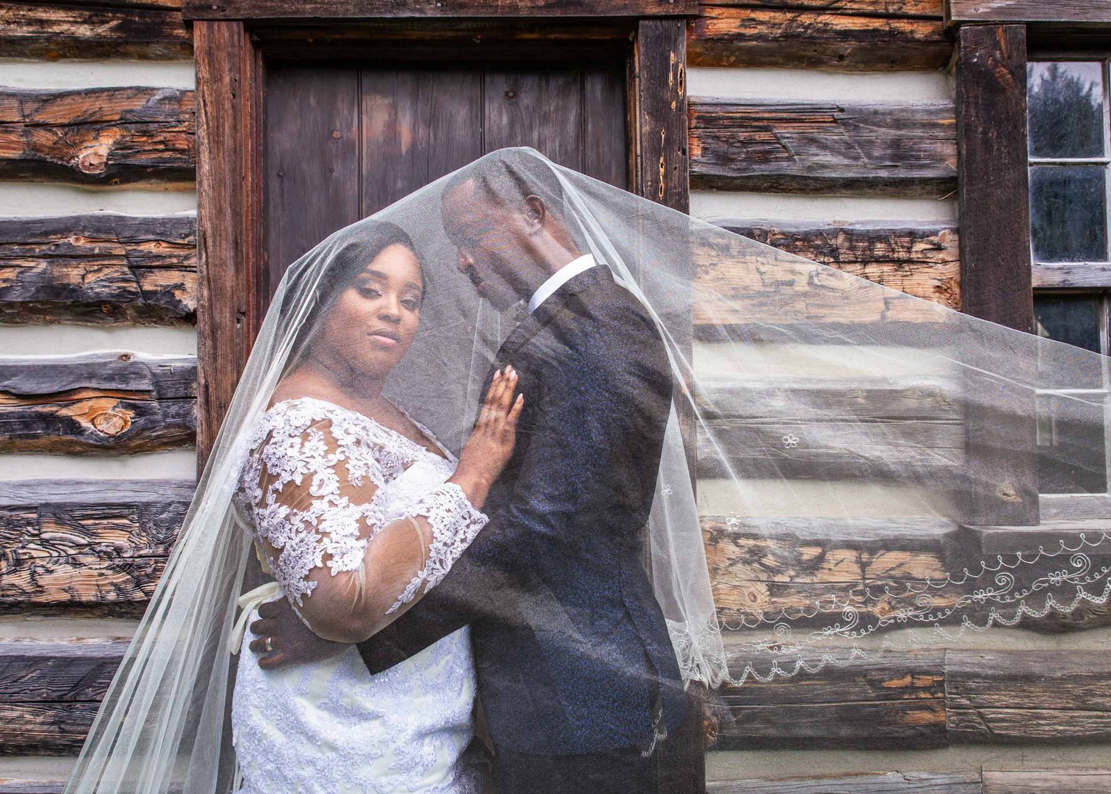 bride and groom covered in veil