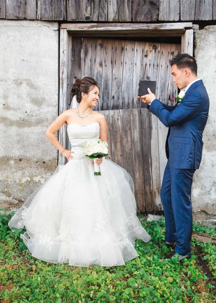 bride posing for photo taken by groom holding camera