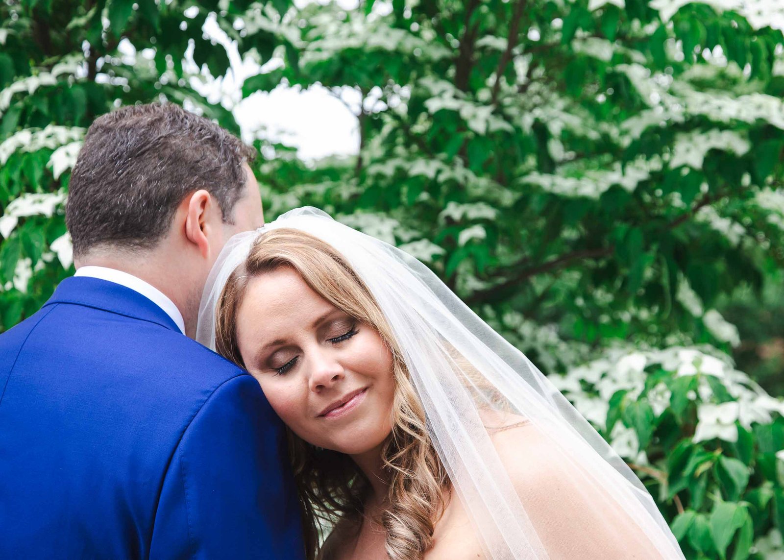 bride rests her head on grooms shoulder