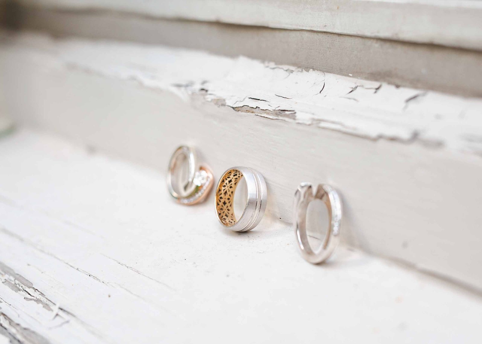 close up of wedding rings on a window sill
