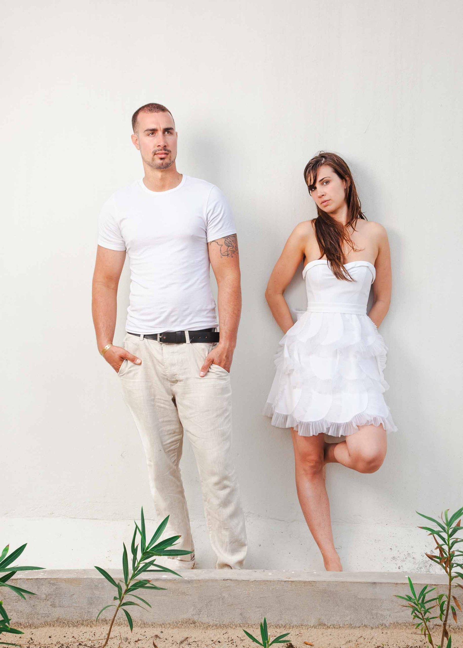 destination wedding jamaica-bride and groom pose against a plain white wall